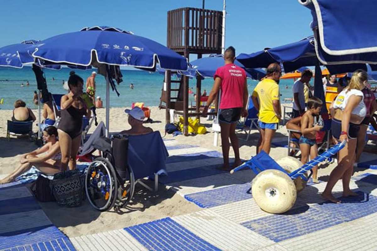 Famiglia con bambini piccoli che gioca sulla spiaggia dorata di San Vito Lo Capo, ombrelloni colorati, mare calmo e limpido, atmosfera rilassata